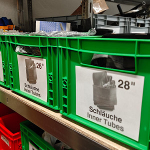 verschiedene Kisten mit Schläuchen stehen im Regal