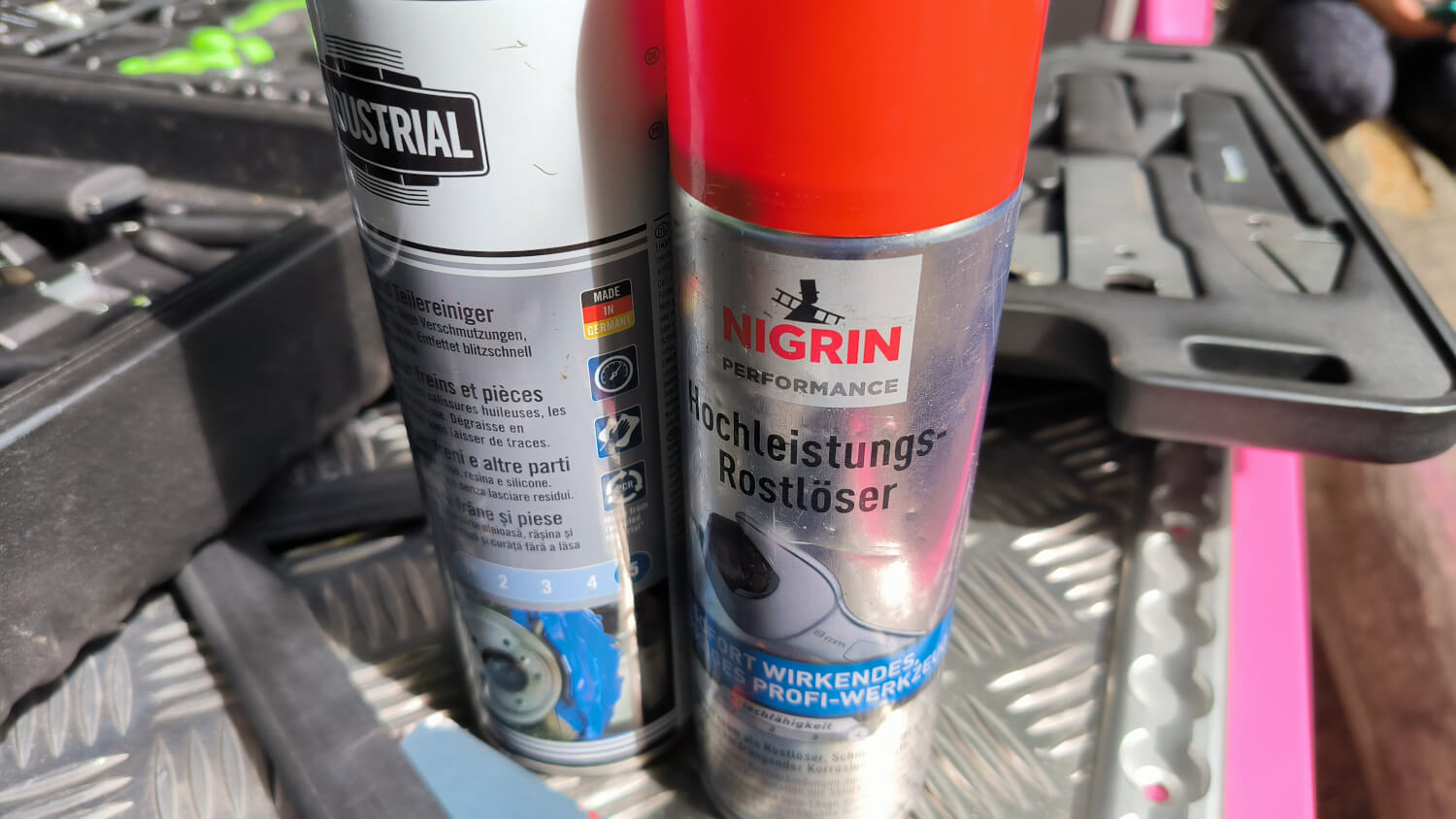 Zwei Spraydosen, eine mit Teilereiniger, eine mit Rostlöser stehen auf dem SCREW-Bike